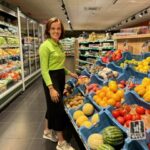 femme dans un rayon de fruits et légumes chez louis delhaize